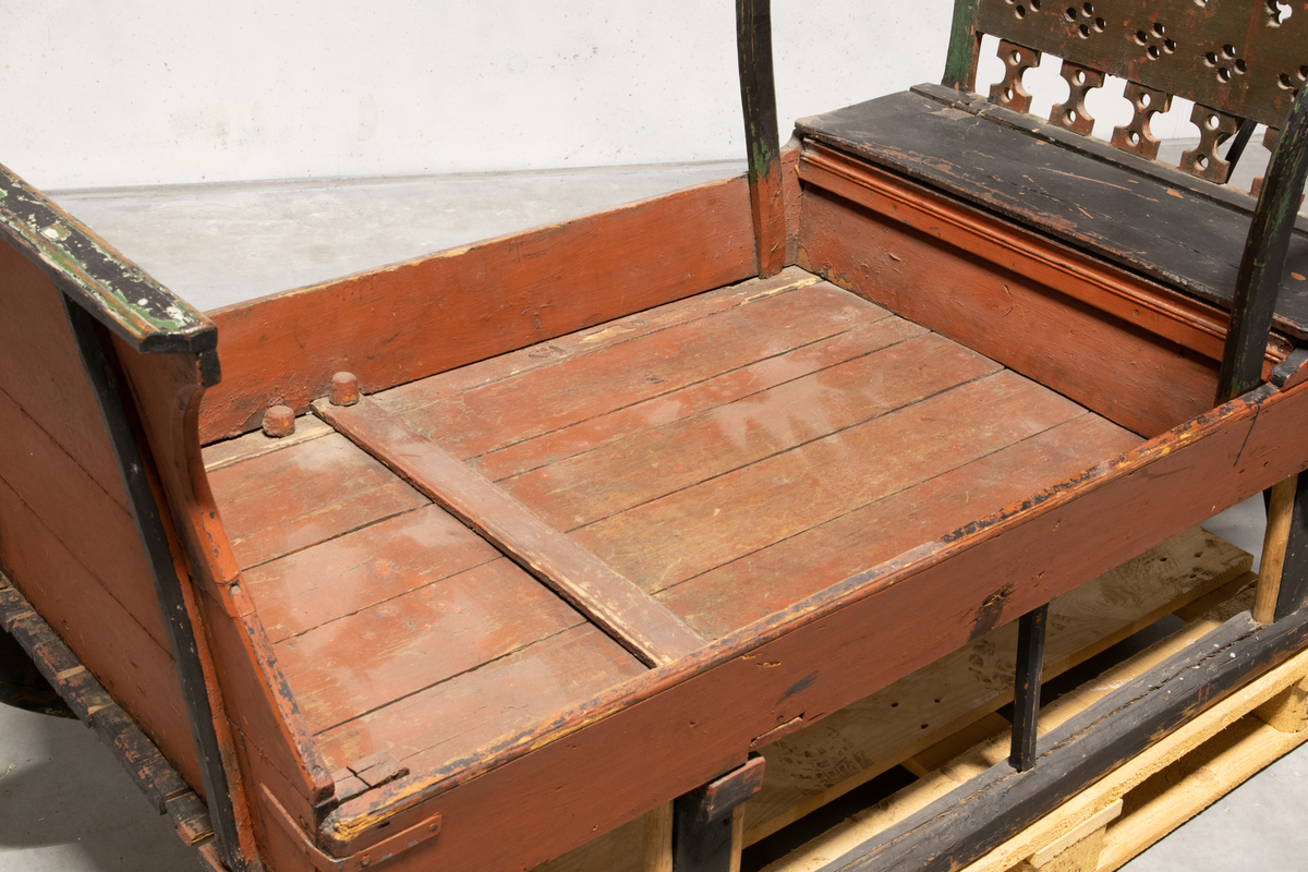 Kjelke med plan toppflate som har lave karmer på langsidene, høyt frontorett med rett topp og sveifede sidekanter. Bakerst på sluffeplanet kasseformet sete med hengslet lokk. Setet har gjennombrutt rygg og bøyleformede sidevanger. Bak på meiene skinnbetrukket kuskesete som hviler på tre bøyde jernstenger.