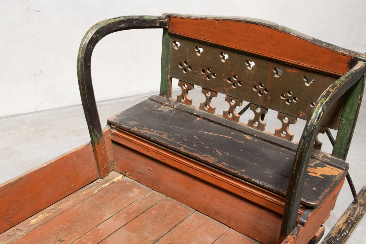 Kjelke med plan toppflate som har lave karmer på langsidene, høyt frontorett med rett topp og sveifede sidekanter. Bakerst på sluffeplanet kasseformet sete med hengslet lokk. Setet har gjennombrutt rygg og bøyleformede sidevanger. Bak på meiene skinnbetrukket kuskesete som hviler på tre bøyde jernstenger.