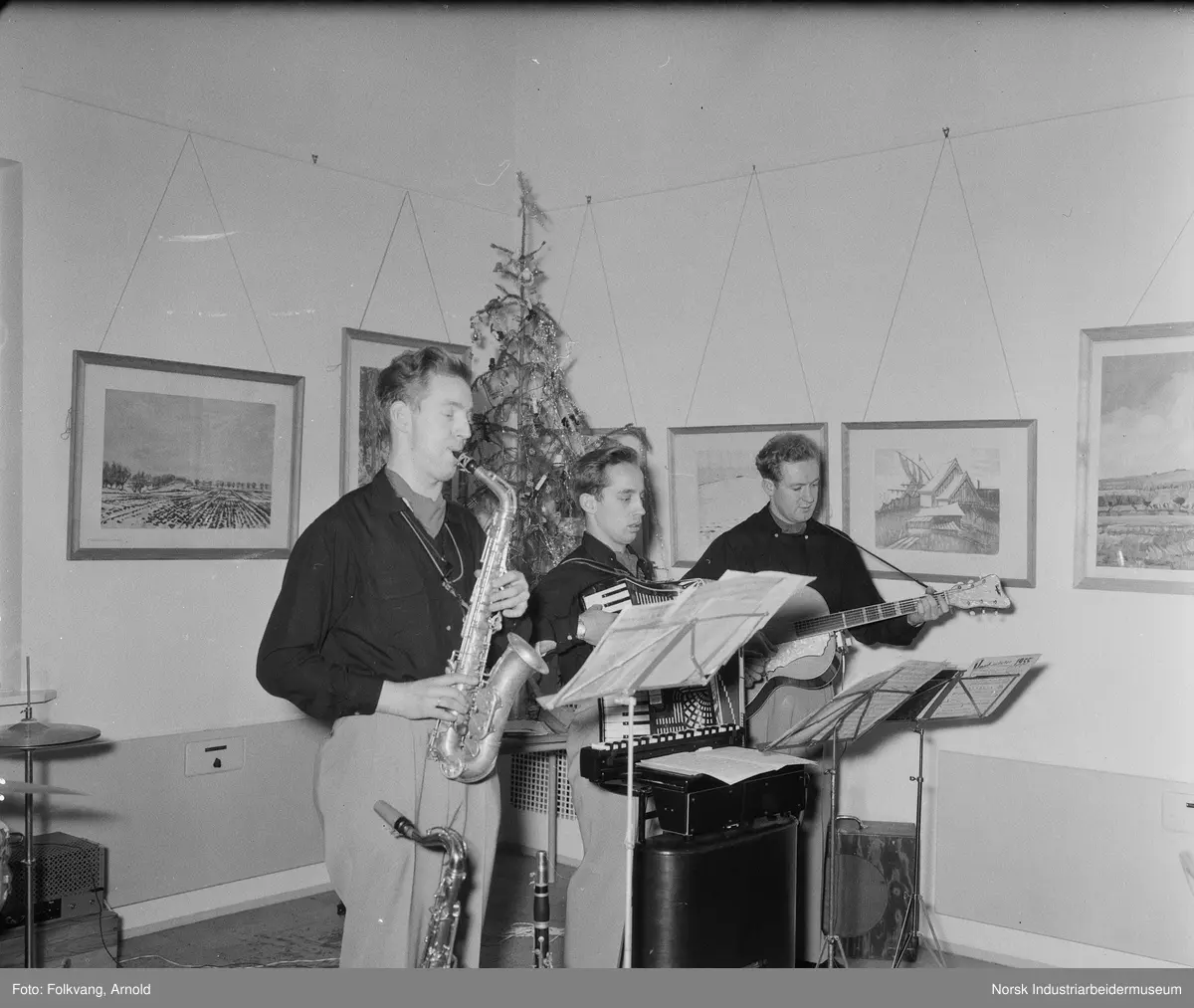 Kulturutvalget arrangerer underholdning i Velferdshuset på fabrikkområdet Rjukan under arbeidernes lunsj. Tre menn spiller instrumenter.