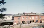 Järnvägsstationen, Växjö, från Museiparken. I bakgrunden skymtar man bl a den nya fastigheten i hörnet Norra Järnvägsgatan/Kungsgatan.
Färgfoto ca 1960.