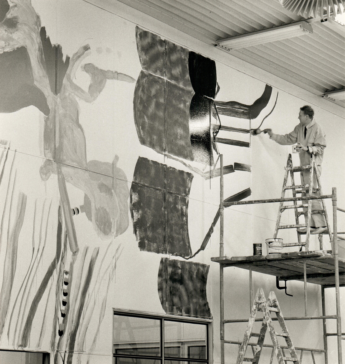 Konstnären Jörgen Fogelquist arbetar med väggmålning samt färgsättning av fabrikslandskap i Frans Suell-tobaksfabriken i Malmö 1967.
