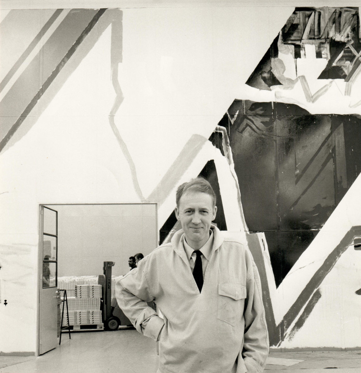Jörgen Fogelquist står framför sin väggmålning i Frans Suell-tobaksfabriken i Malmö 1967.