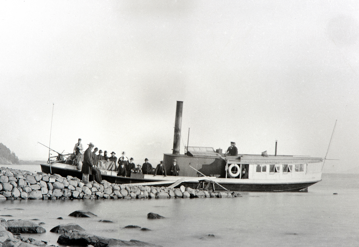 D/S Lettvindt ved Jessnes Brygge i Ringsaker. Kaptein Christian Jensen står i styrhuset. Mjøsbåt. Steinbrygge. Lettvindt var Mjøsas første propellbåt, bygd i 1867. Senere ble den ombygd og døpt Helgøy. Den endte sine dager ved Minnesund i 1960 under navnet Mira. 

Christian Jensen var forøvrig tidligere innehaver av Christian Jensens Eftf. Kolonialforretning i Grønnegata 32 Hamar, som hans datter Karoline Larsen drev i 75 år.