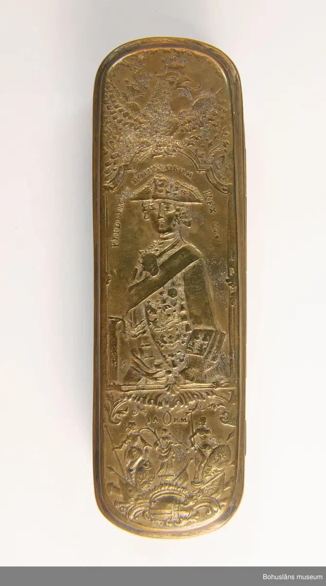 Fredrik II (ty. Friedrich II.), kallad "Fredrik den store" (Friedrich der Grosse), f. 24 januari 1712, d. 17 augusti 1786, kung av Preussen 1740-86; räknas som rökarnas skyddspatron.

Ur handskrivna katalogen 1957-1958:
Tobaksdosa, mässing Fredrik II:s bild
Bottenmått: 16 x 5 H: 3. Föremålet helt.

Lappkatalog: 95