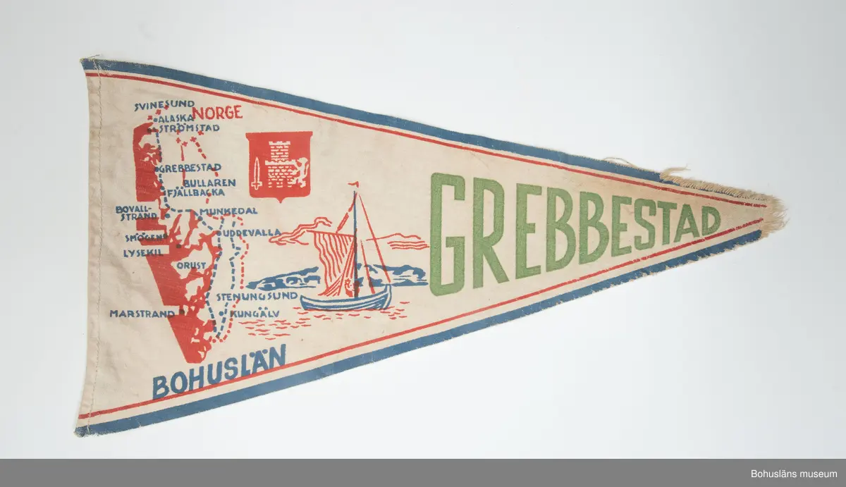 Trekantig vimpel med textiltryck i rött och blått med Bohusläns vapen och landskapskarta samt seglande båt, namnet "Grebbestad" i grönt. Blå kant. En kant stadkant, en skuren och en fållad.
Sammanhör med UM026180-UM026184
Användar- och förvärvsuppgifter se UM026180