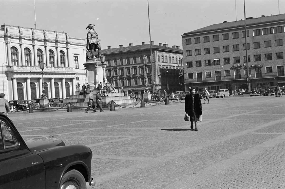 En person på stor åpen plass med statue