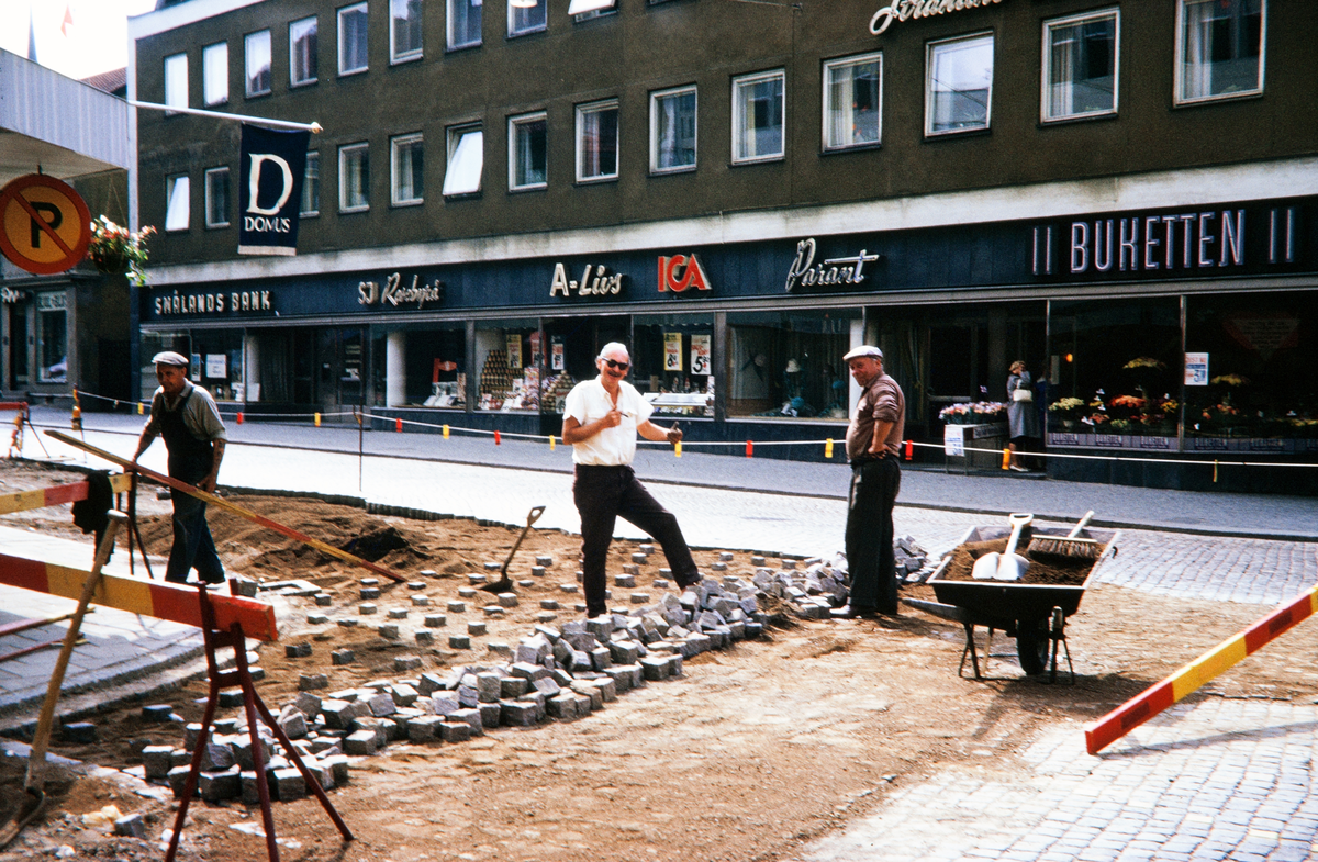 Gatuarbete (gatstensläggning) på Storgatan utanför det nya Domusvaruhuset, i korsningen mot Klostergatan.
Färgfoto ca 1970.