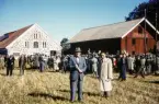 Auktion (?) vid stenladugårdarna på Teleborgs slott. Mycket folk har samlats. En traktor skymtar i folkhavet.