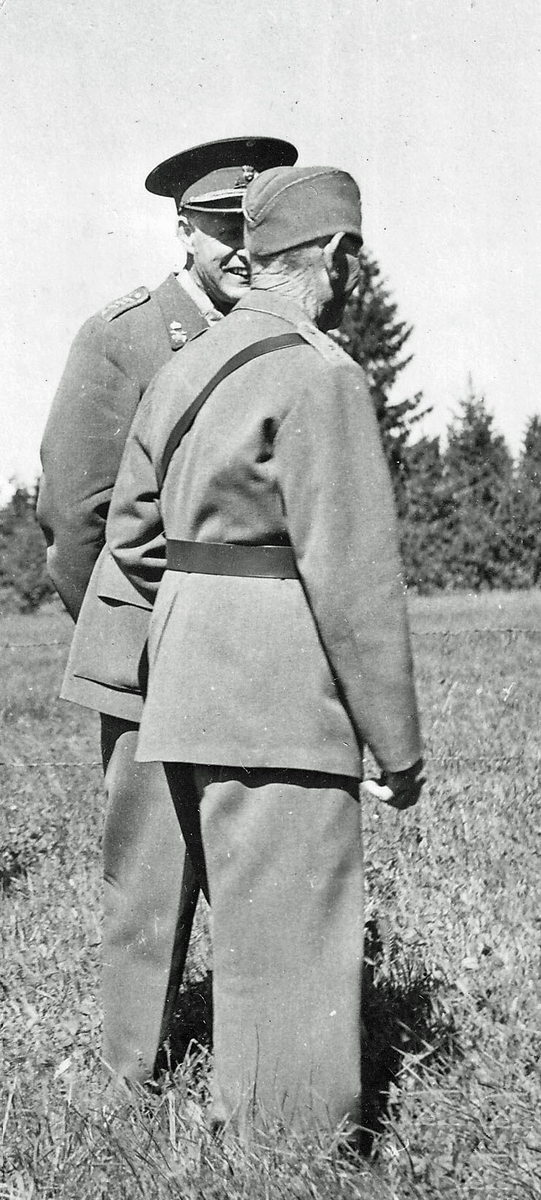 Indelte soldaten Claes Hellgren utanför sitt boställe i Vårkumla och visar ägorna för regementschefen P 4, Hans Malmgren 1957-08-03.