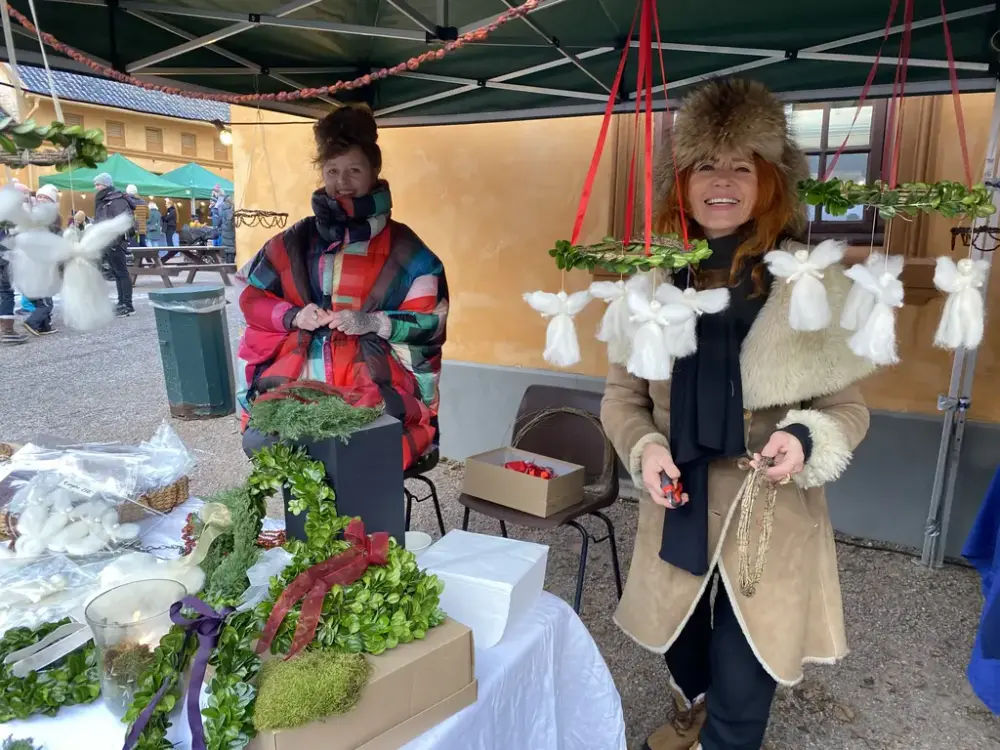 To kvinner selger julekranser på julemarkedet. 