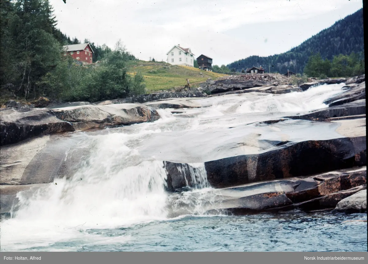 Badeplassen Røyslandsbergo i Atrå. Gård med våningshus, driftsbygg og stabbur i bakgrunnen.