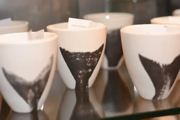 Bildet viser nydelige kopper med ulike fiskehaler i sort på hvit bakgrunn, kopper laget av den norske kunstneren Cecilie Haaland