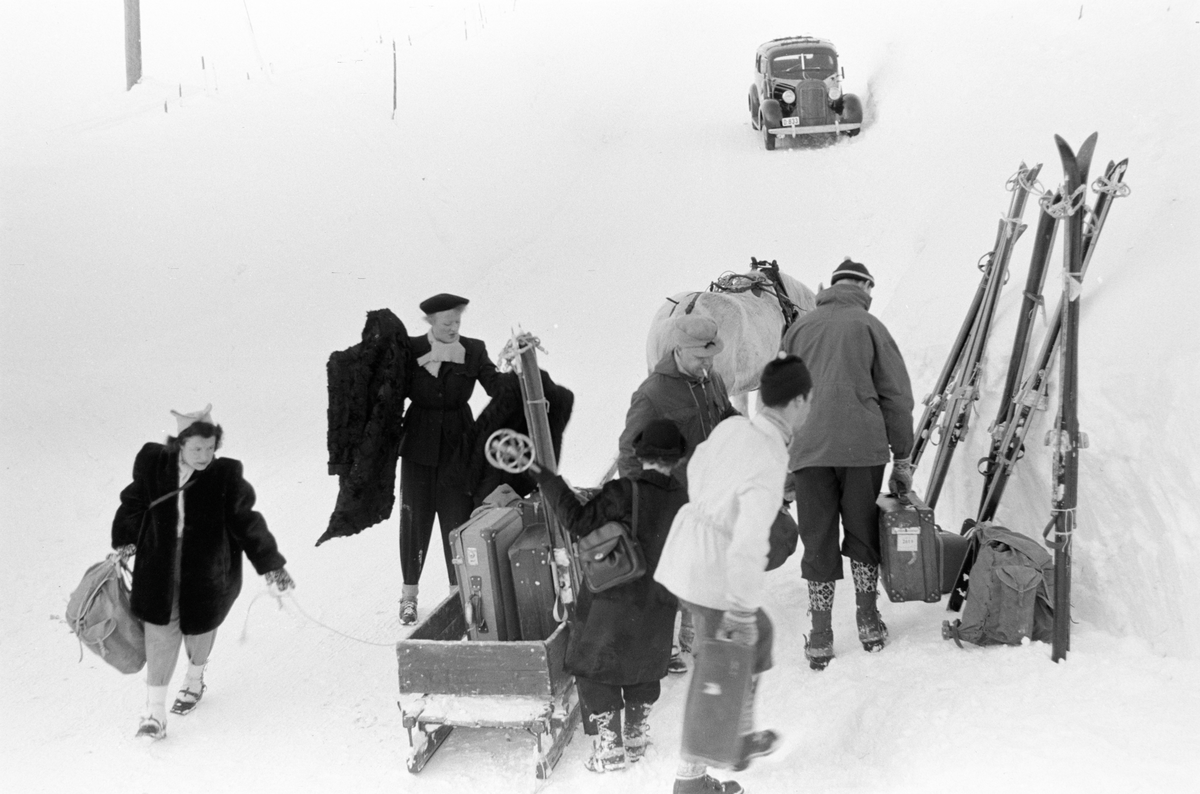Gruppe mennesker med skiutstyr og bagasje