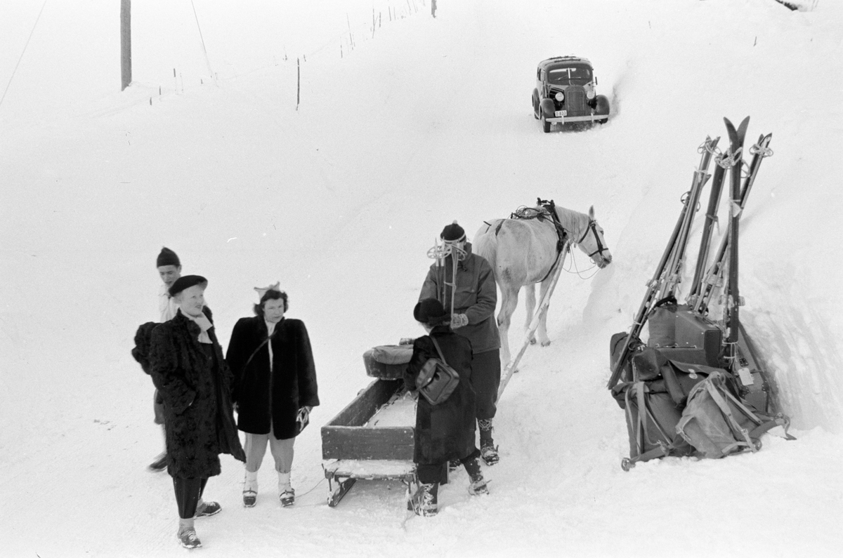 Gruppe mennesker med skiutstyr og bagasje