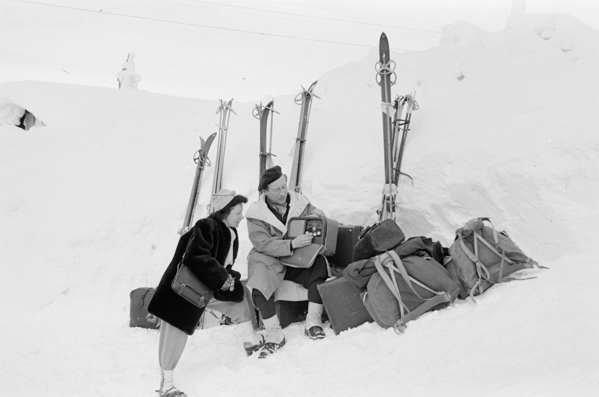 Gruppe mennesker med skiutstyr og bagasje