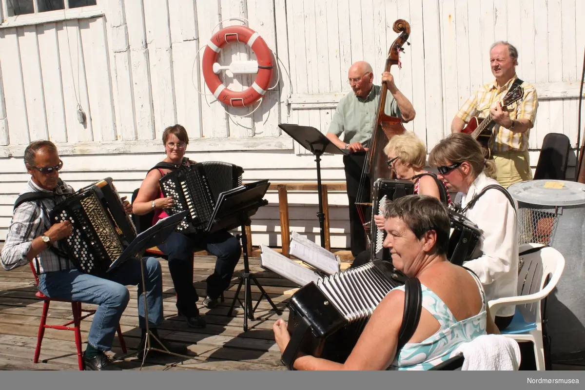 Musikk på platten. Arrangementsfoto fra "Familiedagen" i regi av Nordmøre museum på Milnbrygga, Gomalandet i Kristiansund. Bildet er datert 21. juni 2009. Fotograf er Roar Leite ved Nordmøre museum. Fra Nordmøre museums fotosamlinger.