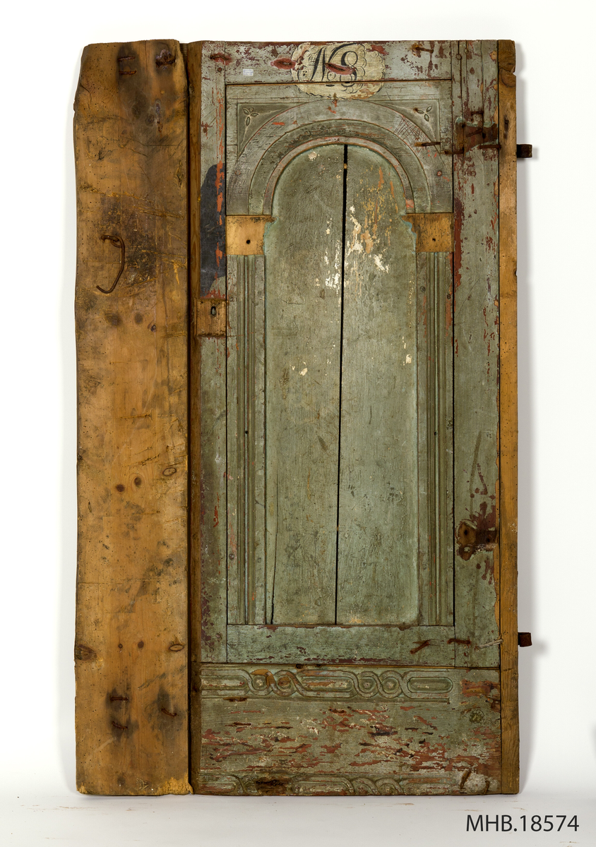 Dør. Liten malt dør, med jernbeslag på bakside og med en glatt treplate (umalt) på venstre side. Pånaglet pilaster med kapitel og rundbue. Pilastrene har en enkel dekor med to utskåret-  og vertikale halvrunde lister. Stykket over omkring rundbogen er flate, med to små tre blader blomster på hver hjørnet. Dekor med et lite ovalt felt i hvitt og med inskripsjonen nr. 8 på den øvre listverk av døren. Nederst har settet et horisontal listverk med rankeornament i flatskurd. Rødmalt på baksiden.