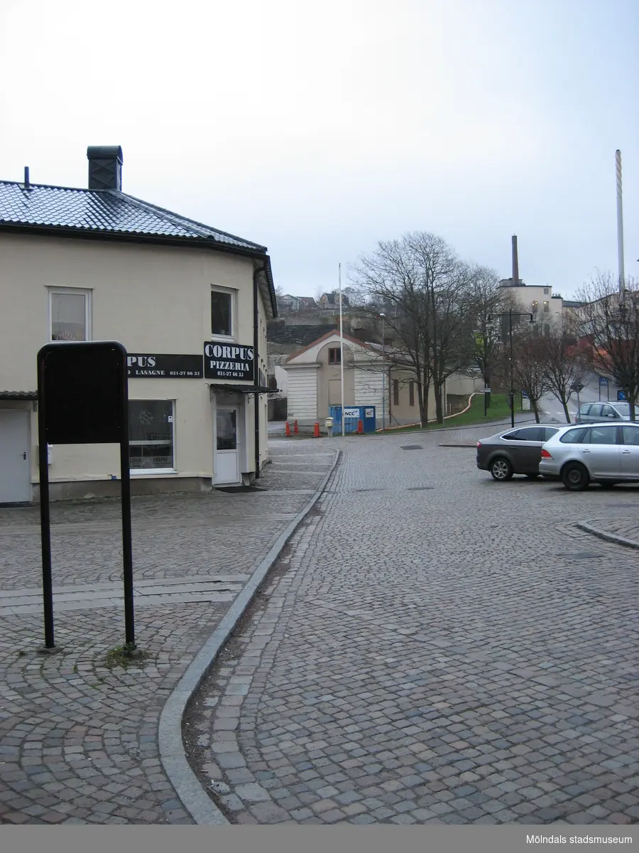 Vy österut över det stenlagda Gamla torget utmed Kvarnbygatan år 2011. Till vänster ses Corpus Pizzeria (Gamla torget 45), några parkerade bilar samt Götiska Förbundets friskola (1842-1925). Innanför skolan ses rivningsrester från SOABs industriområde (1916-2007). I fonden längre upp till höger ses "Strumpan" (beige hus med skorsten, Kvarnbygatan 10-14).
Relaterade motiv: 2024_1309 - 1324.