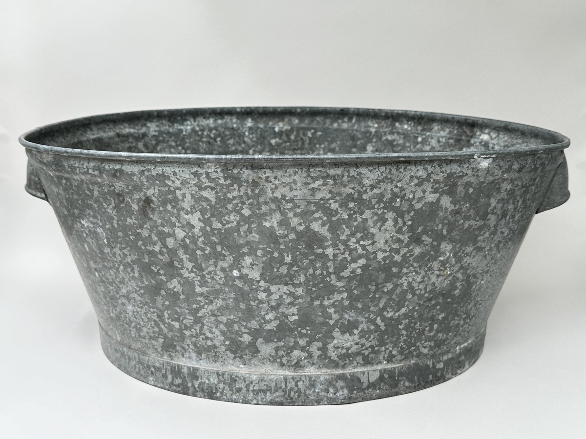 Balja, diskbalja av galvaniserad plåt. Oval form, med ett skålhandtag på var kortsida. 