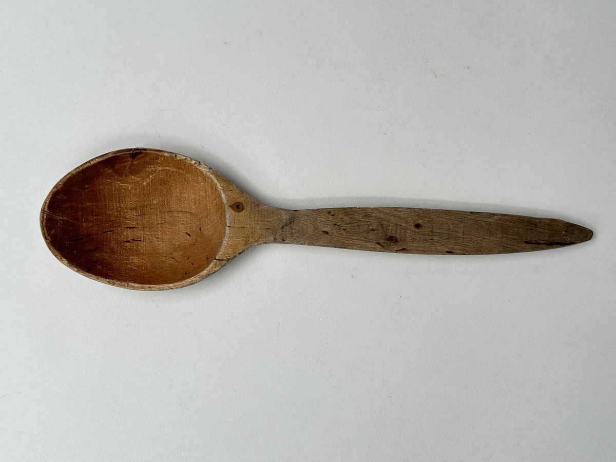 Slev av trä. Handsniden. Bruksslitage, spricka i skålen. 
