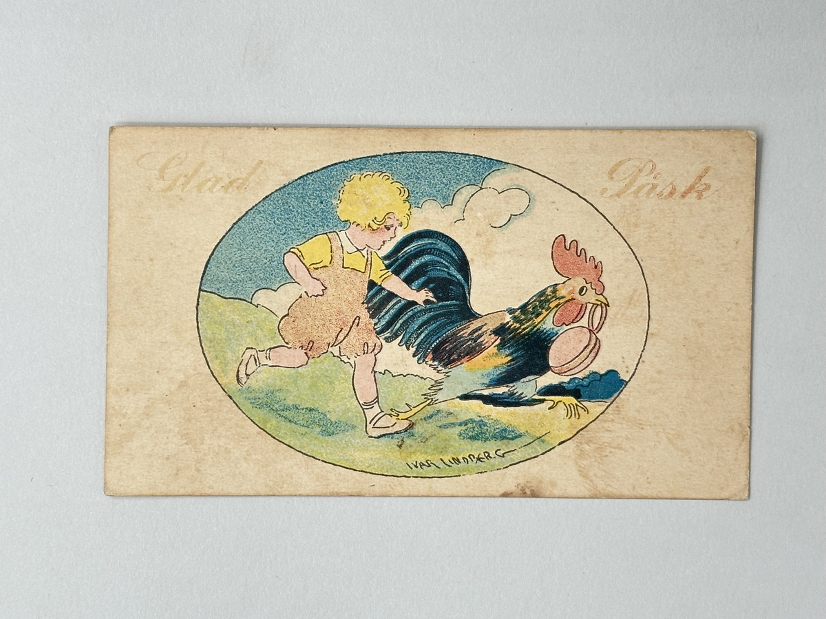 Påskkort i kartong. Vit kartong med röd text: Glad Påsk. Oval bild: blå himmel, vita moln, grönt gräs. Blont barn i röda byxor jagar tupp som bär ett ägg i rött band med näbben. Frankerat med rött femöresfrimärke med lejon. Motivet blekt. 