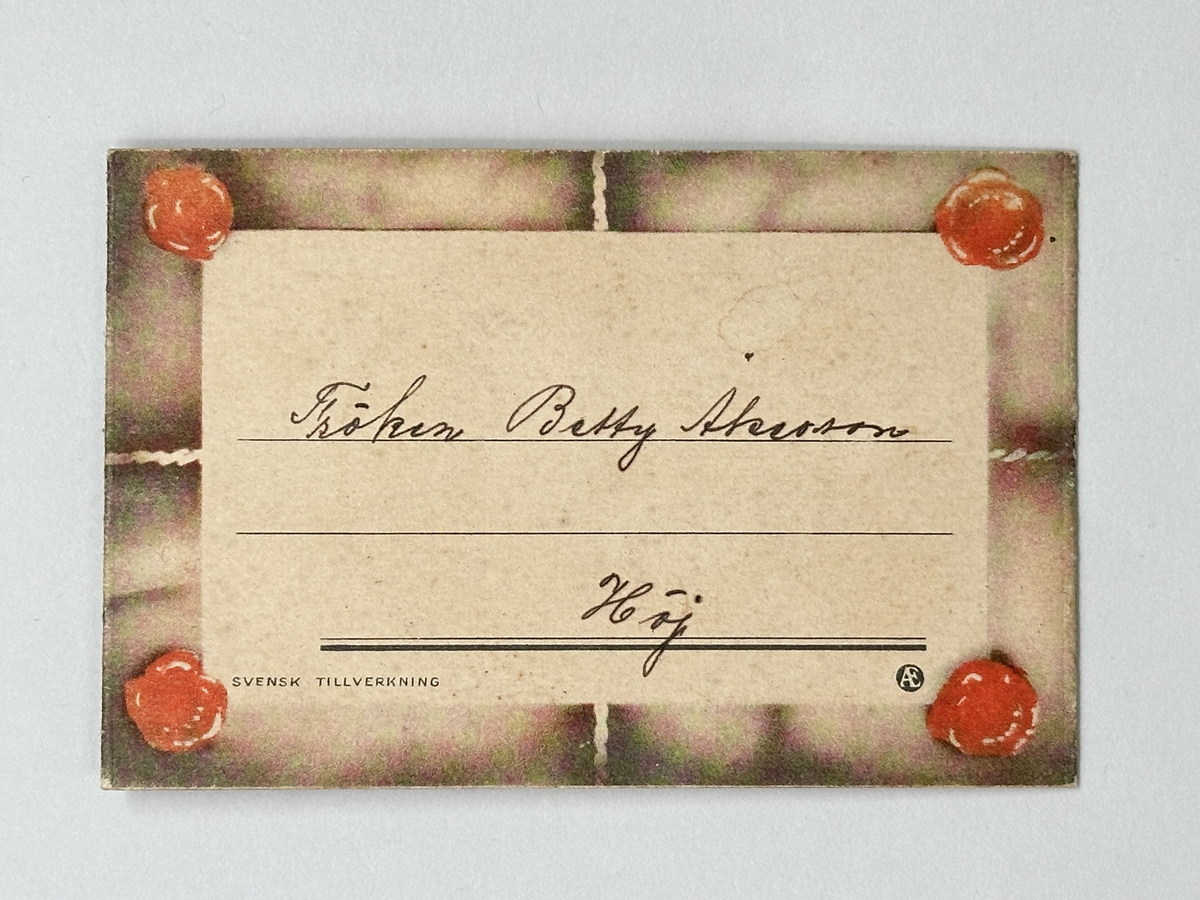 Gratulationskort i papper. Hopvikbart så det ser ut som kuvert med snöre om, sigill och adressblad. Inuti tecknade blommor och blad samt rund bild föreställande sommarlandskap med sjö och björkar. Tryckt dikt. 