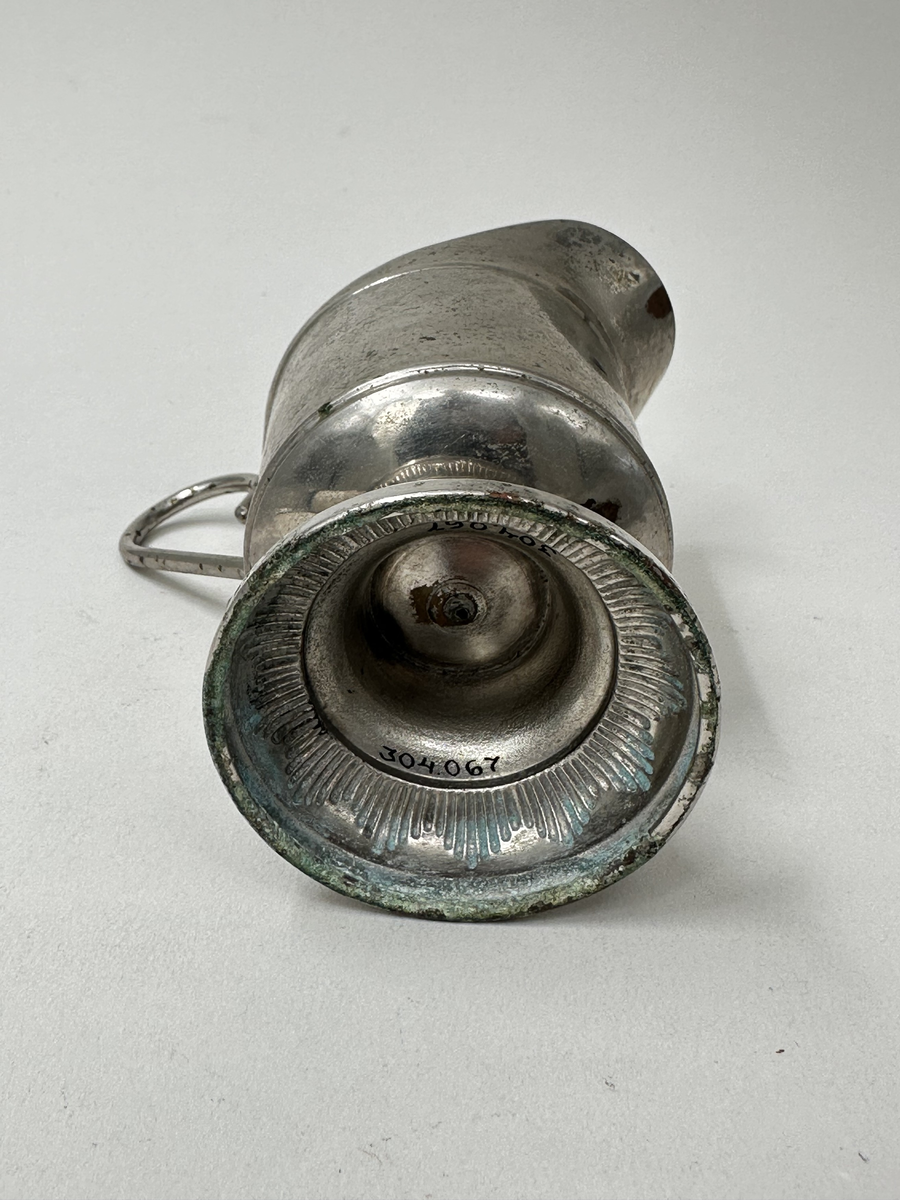 Gräddsnipa i nickel. Cicelerad dekor i form av bladrankor och parallellogram. Lodgrepe. Hög fot med spetsig dekor i reliefränder.