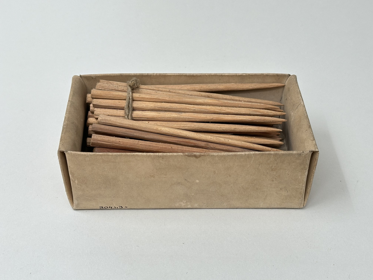 75 handtäljda stickor av furu. Oanvända. Liggandes i öppen ask av naturfärgad papp.