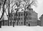 Apotekaregatan 15 i Linköping omkring förra sekelskiftet. Utblick från Domkyrkoparken. Tiden för husets tillkomst har inte konstaterats inom ramen för denna uppgift. Det revs dock 1966 för att med tomten bidra till utrymme för det blivande Nämndhuset.