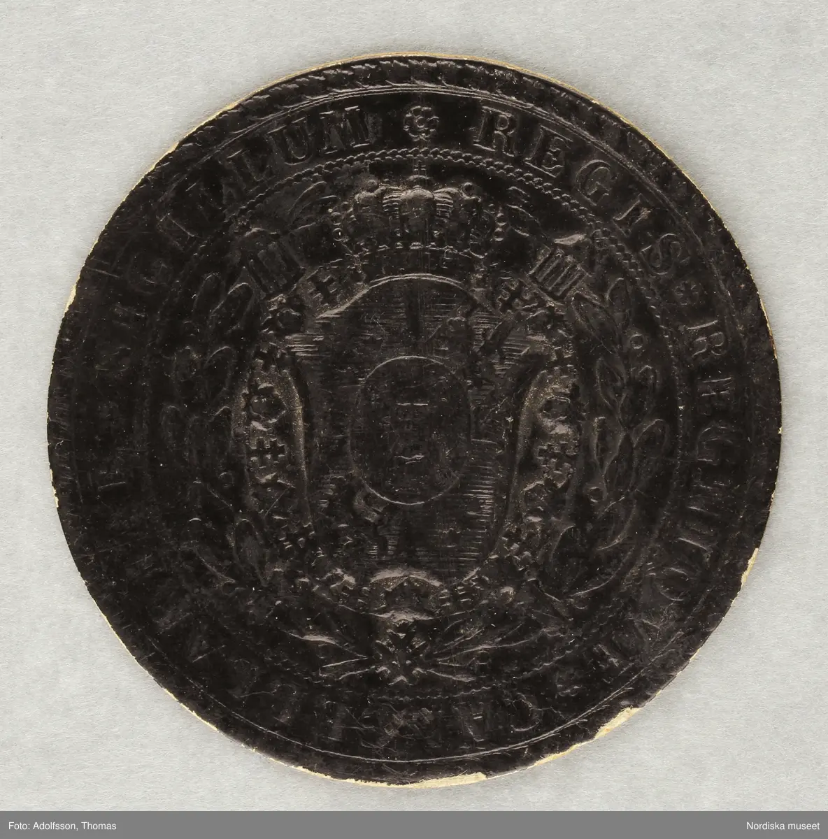 Huvudliggaren:
"Riksdagspoletter av papp, runda 4 gula och 1 svart, utfärd. för Liss Olof Larsson åren 1867, 1870, 1873, 1876, samt kyrkomötet 1878.. 5 st.
G 21/3 1904 Liss Lars, kapten, Vaxholm."