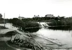 Kvarnholmen med Västerbron, sedd från parken. Fotografiet är taget omkring 1865 då Teatern är färdig och Kockska huset ännu inte är rivet.