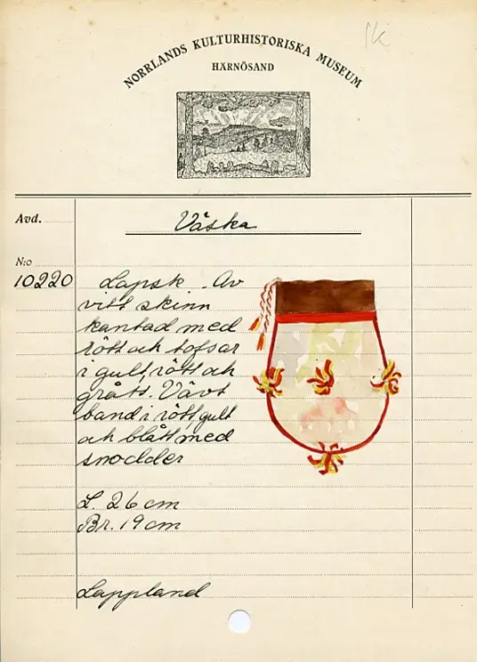 Beskrivning: Väska. Handsydd. Överdelen av garvat skinn. Nederdelen av två sidostycken. Sidostyckena av rundskurna stycken av getpälsskinn. L. 21,5 x B. 18 cm. Mellanlägg av dubbel, ljus, orangefärgad bomullskypert i sömmen mellan de två sidostyckena. Tofsar av grått och rostfärgat, tvåtrådigt ullgarn och orangefärgat bomullsgarn fästade i mitten på sidostyckena, mitt i var sidsöm och mitt i bottensömmen. Överdelen skuren i ett stycke med mellanlägg av ljus, orangefärgad bomullskypert i sidsömmen. I sömmen mellan överdelen och nederdelen mellanlägg av dubbelvikt, 1,5 cm bred, rostfärgad bomullkypert. Kanten på överdelen nervikt mot avigsidan och sydd till en dragsko med öppning åt endast ett håll. Ett snöre i dragskon, vars ändar antagligen är uppätna av djur och därför ej går att beskriva. Upphängningsband vävt av rött, gult och klarblått ullgarn i varpen och lila ullgarn som inslagstråd. En snodd fläta av rött och gult ullgarn i fyrflätning som bildar ett randigt mönster fastsydd i ena änden på bandet. En snodd flätat av gultrött och lila ullgarn, flätat i fiskbenmönster, fästat i bandets andra ände och fastsydd i överdelens sidosöm. Fästena mellan bandet och snoddarna dolda av rött kläde. Den fyrflätade snodden är fastknuten i en snodd av tvinnat, grått och rostfärgat ullgarn, som i sin tur är fastsydd i överdelens andra sida. Väskan är helt och hållet sydd med bomullstråd. 