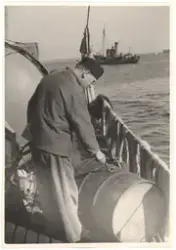 En sjöman fyller ett oljefat.