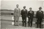 Medaljörer på bro. Vägräcke med stengardister. Stenbro i bakgrunden.