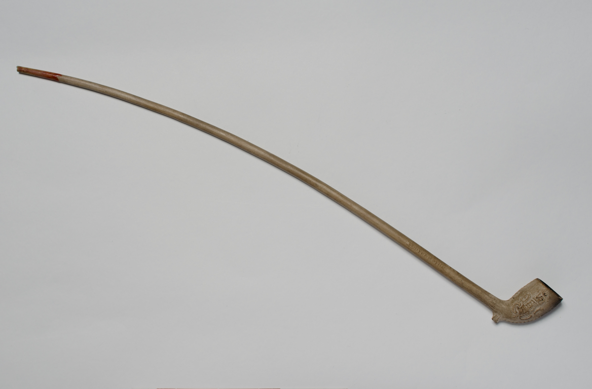 Krittpipe, dekor på pipehode (våpenskjold og et hode) 1700-talls. Hvit med rødt munnparti.