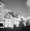 Gatuhuset till Drottninggatan 7 i Linköping, flankerad av sina festliga sidobyggnader. Sammantaget en förfallen skönhet fotoåret 1955.