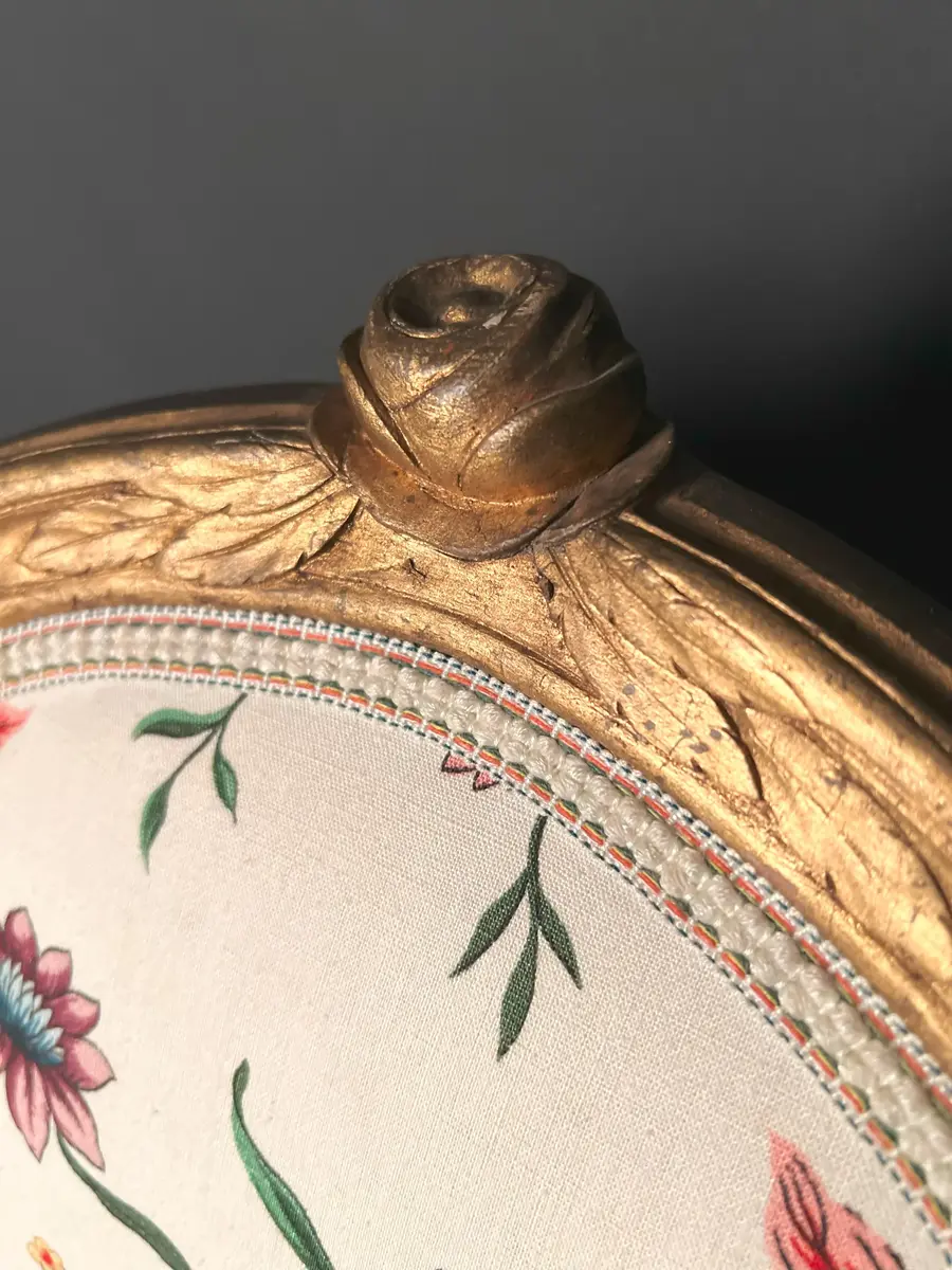 Ett par stolar i gustaviansk stil. Raka, räfflade och neråt avsmalnande ben. Sargen är rak och prydd med hörnrosetter ovanför benen. Framsargen har en blomdekor i mitten. Ryggen har en oval form och är krönt med en snidad ros. Ryggens mitt samt stolens sits är stoppade och klädda i ett vitt tyg med blomsterdekor i grönt, rött och blått. Stolens stomme är förgylld. Ursprungligen har stolen varit klädd i svart läder och ryggens baksida med rött tyg.