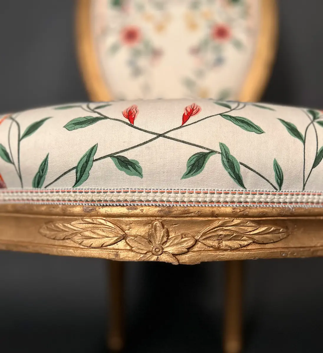 Ett par stolar i gustaviansk stil. Raka, räfflade och neråt avsmalnande ben. Sargen är rak och prydd med hörnrosetter ovanför benen. Framsargen har en blomdekor i mitten. Ryggen har en oval form och är krönt med en snidad ros. Ryggens mitt samt stolens sits är stoppade och klädda i ett vitt tyg med blomsterdekor i grönt, rött och blått. Stolens stomme är förgylld. Ursprungligen har stolen varit klädd i svart läder och ryggens baksida med rött tyg.