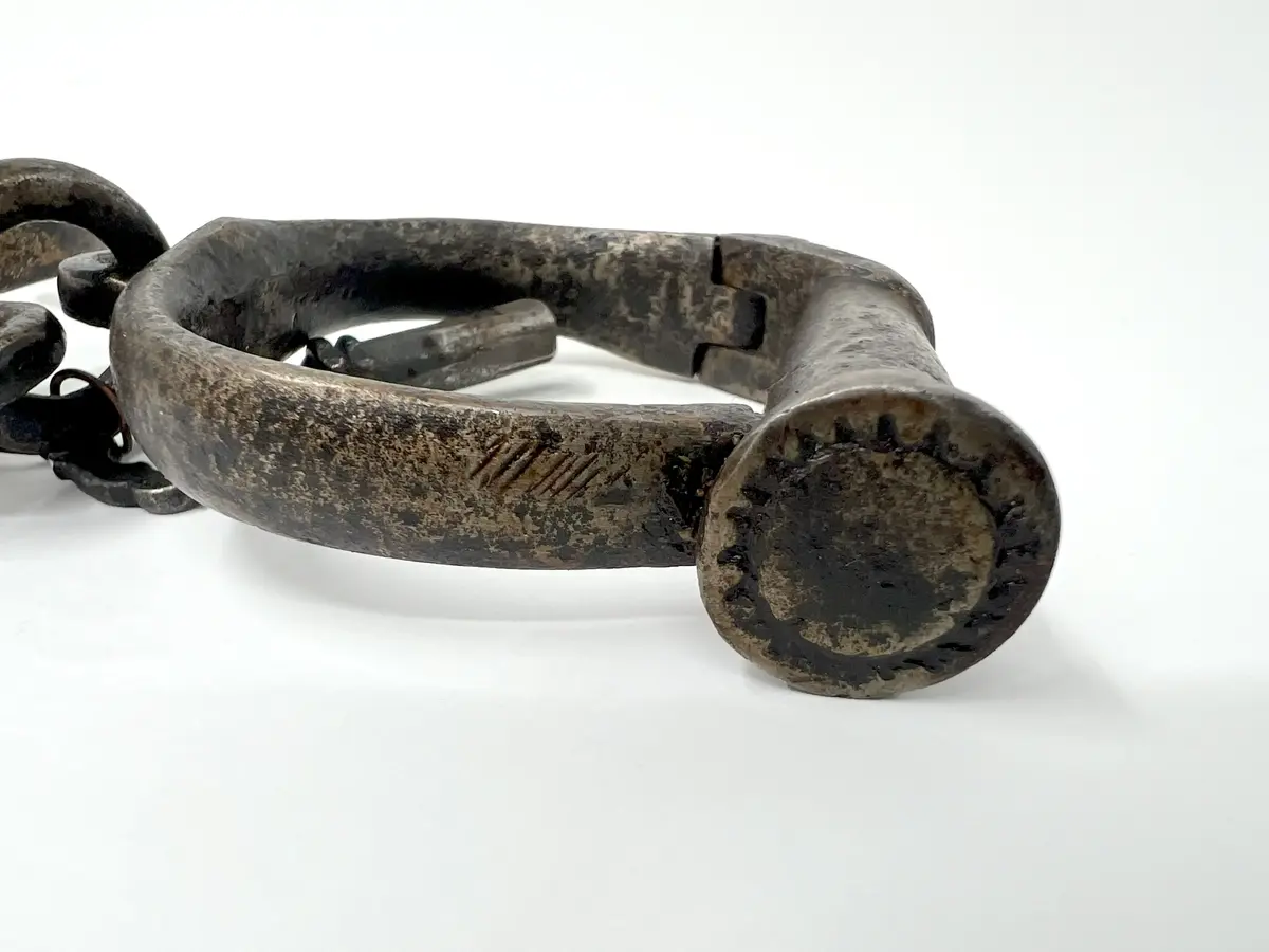 Handklovar, av järn. Består av två U-formade järn, som tillsammans med en cylinderformad del bildar en sluten ring. I cylindern sitter låset, som öppnas och låses med en nyckel i ett nyckelhål på cylinderns ena kortsida. Dessa klovar förenas av två ringar och en däremellan placerad länk, som består av två delar, som kan vridas kring varandra runt sin egen axel. Cylinderns största kortsida är ornerad med soliknande ornament.