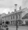 Miljö i Linköping som fullständigt utraderats sedan bilden togs 1955. Parti av Repslagaregatan i höjd med Lilla torget (Gyllentorget). Huset som bland andra inrymde populära Glassbaren bar gatunummer 25.