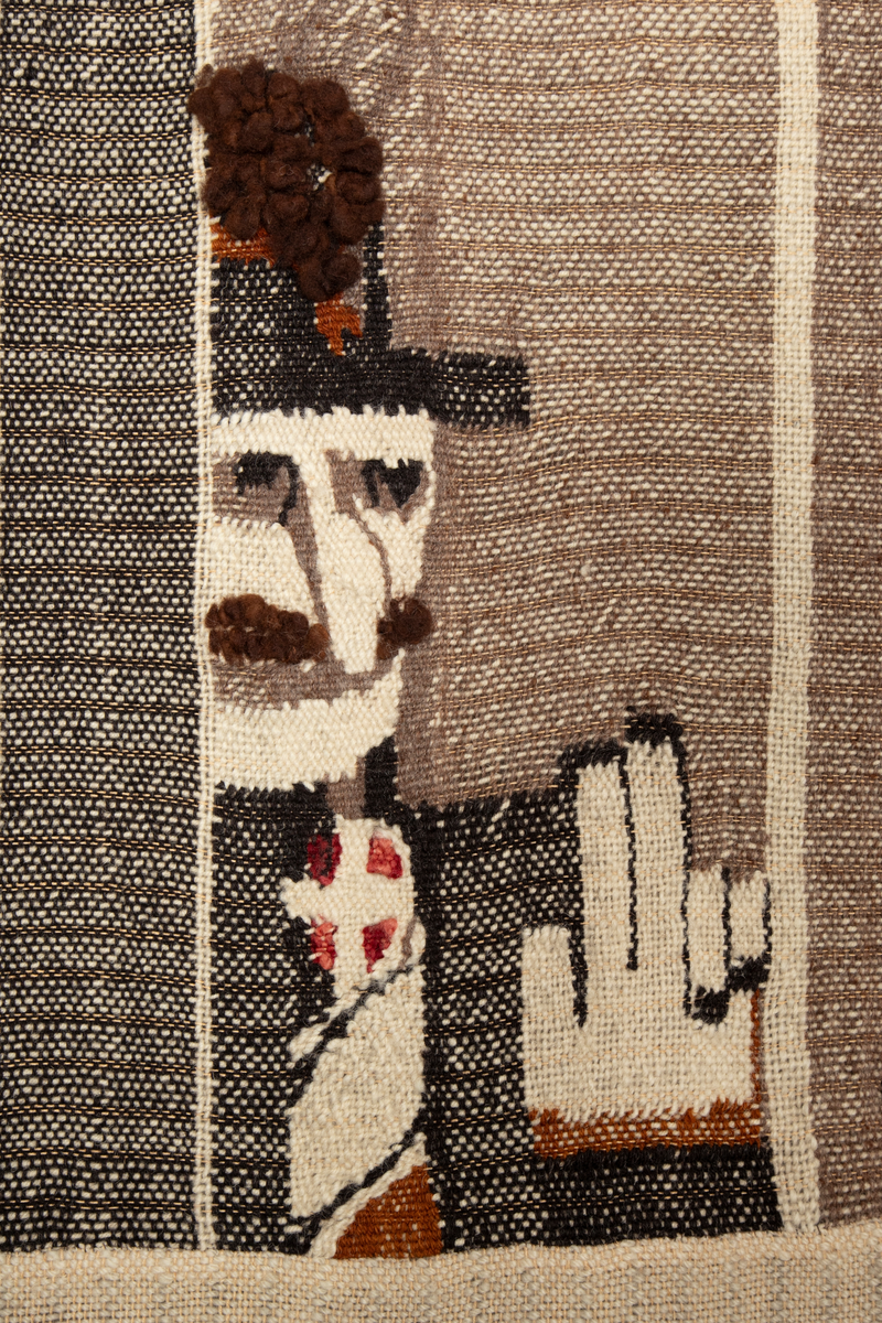 Todelt motiv, med figurativ frise øverst og nonfigurative/asbstrakte fargefelt med arkitektoniske elementer i nedre del. Motivet i øvre del av verket er delt inn som et figurativt triptyk. I heraldisk høyre panel ser vi en representasjon av en ikke navngitt etiopisk kvinne, og ved siden av henne følger ornamenter som også kan leses figurativt som spyd eller piggtråd. I midtpanelet sees en mannsfigur med hatt. Han betegnes noen steder som Storbritannias utenriksminister Anthony Eden, andre ganger som den franske politikeren Pierre Laval, den italienske kongen Vittorio Emanuele III eller Italias ambassadør i Etiopia. Deretter følger ni hender som rekkes opp som i forsvar fra frisens nedre linje. I den andre enden av midtfeltet er Etiopias keiser Haile Selassie fremstilt; hans navn er også vevd inn med bokstaver øverst i feltet, over hendene. I heraldisk venstre panel ser vi en representasjon av en anonym etiopier med Benito Mussolinis avhugde hode på et spyd. Under hodet sees bokstavene "hr. M", vevd i rødt.