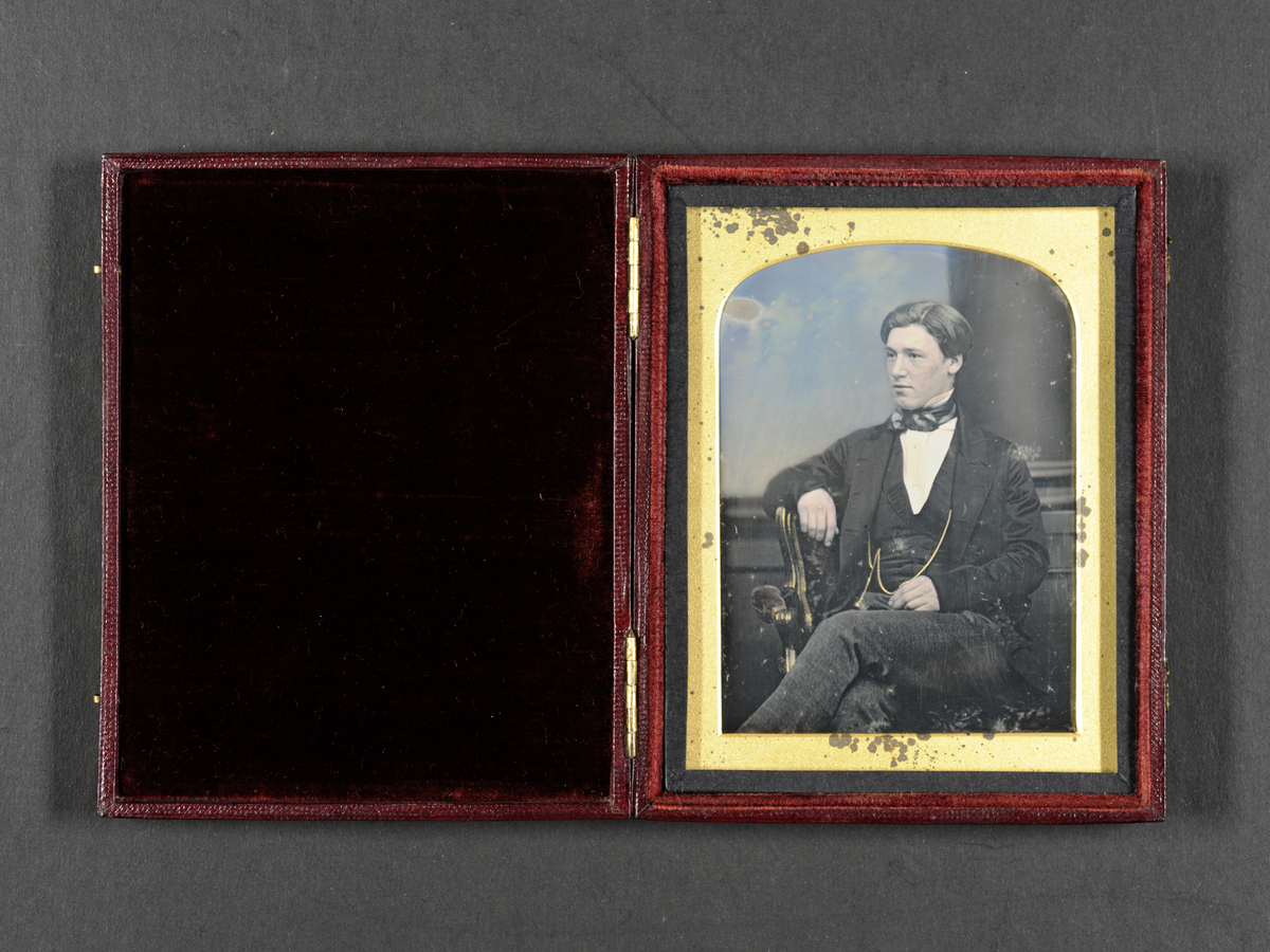 Daguerreotypi: Portrett av sittende ung mann, 3/4 profil. Håndkolorert.
