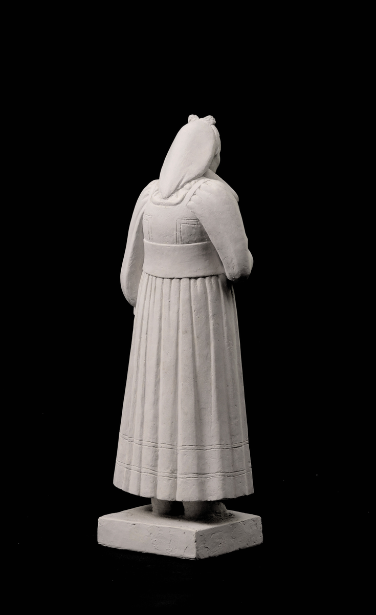 Kvinne iført folkedrakt, heilfigur, med eit knippe nyklar.