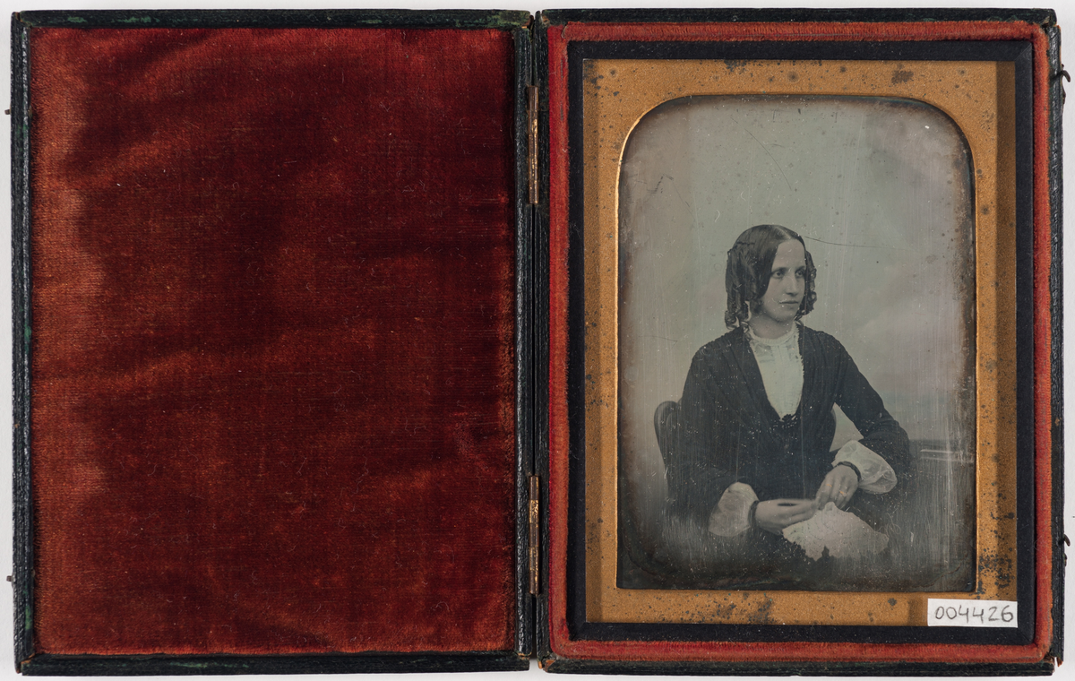 Daguerreotypi: Portrett av en sittende kvinne med krøller, halvfigur.