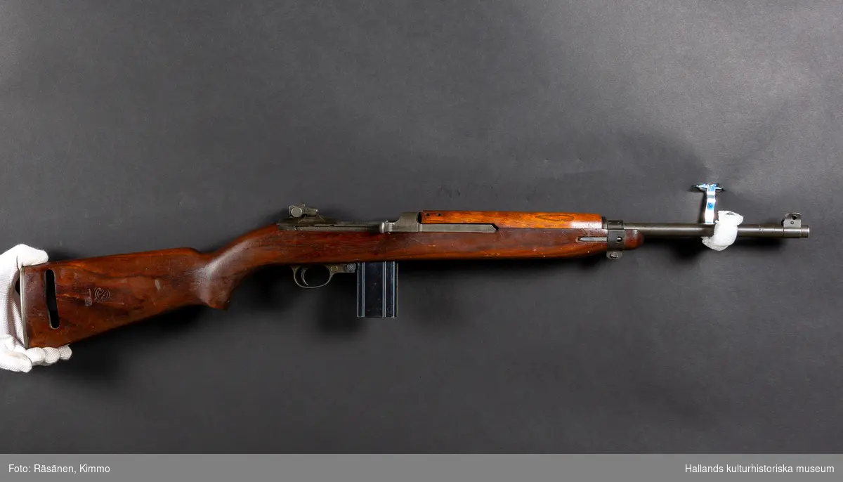 Maskingevär, halvautomatisk. Med kolv och handgrepp i ett stycke.Märkt över slutstycket: "U.S. CARBINE CAL. 30 MI". Märkt vid siktet: "INLAND DIV 5235820". Märkt på pipan: "INLAND MFG. DIV GENERAL MOTORS 5-44."