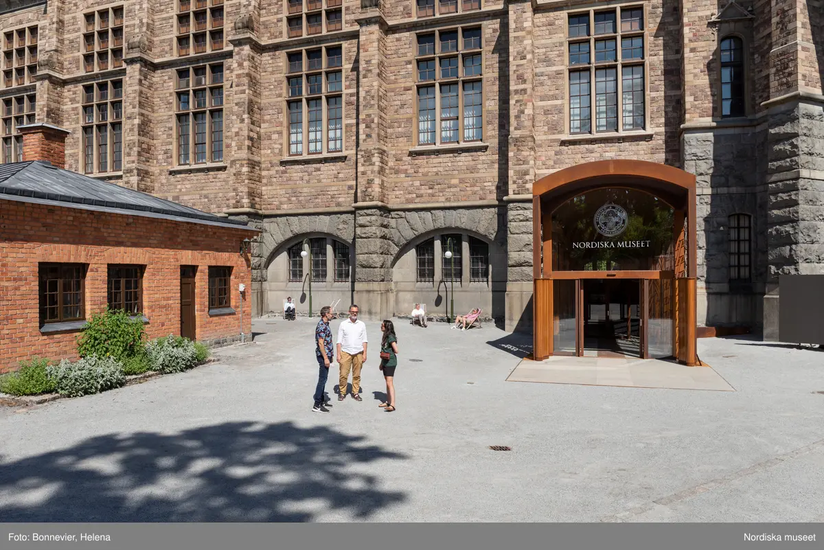 Exteriörer från Nordiska museets västra sida, bakgården, med den nya entrén och byggnaden Lusknäppen. Entrén är ritad av Lone-Pia Bach. Konstnären Outi Pieski står för den konstnärliga gestaltningen med konstverket Two Directions, inspirerat av föremål ur museets samiska samlingar.