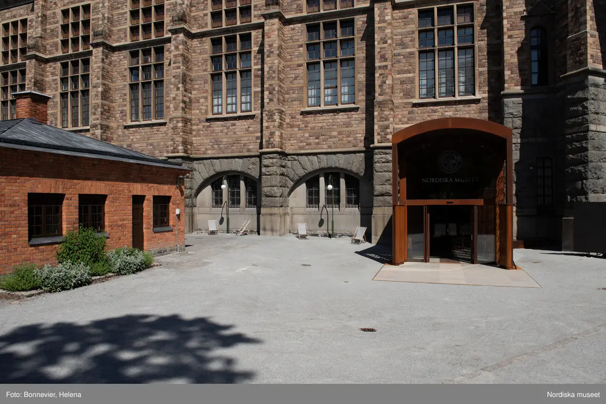 Exteriörer från Nordiska museets västra sida, bakgården, med den nya entrén och byggnaden Lusknäppen. Entrén är ritad av Lone-Pia Bach. Konstnären Outi Pieski står för den konstnärliga gestaltningen med konstverket Two Directions, inspirerat av föremål ur museets samiska samlingar.