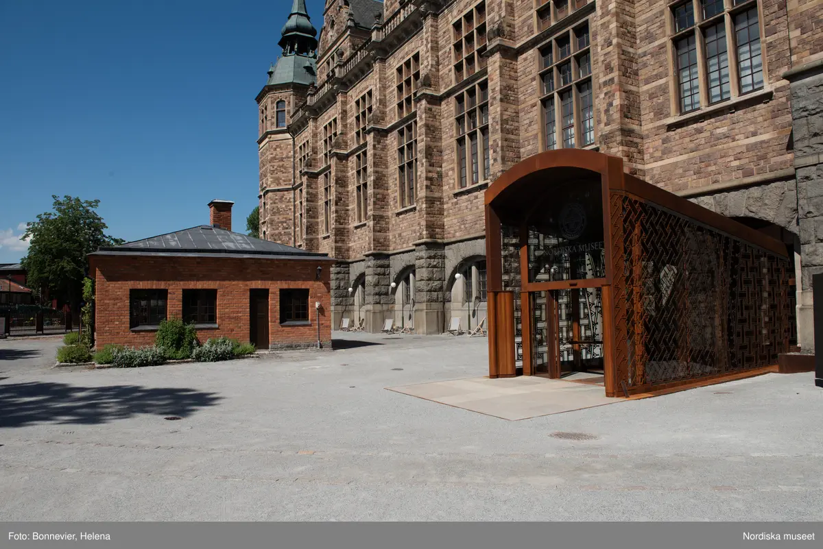 Exteriörer från Nordiska museets västra sida, bakgården, med den nya entrén och byggnaden Lusknäppen. Entrén är ritad av Lone-Pia Bach. Konstnären Outi Pieski står för den konstnärliga gestaltningen med konstverket Two Directions, inspirerat av föremål ur museets samiska samlingar.