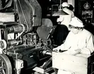 Vid samma maskin som hon förut skött i många år på Tobaksbolaget tillverkar fröken Gerda Kjellman klassiska Bridge i Tobaksmuseet på Skansen, 1960-tal.