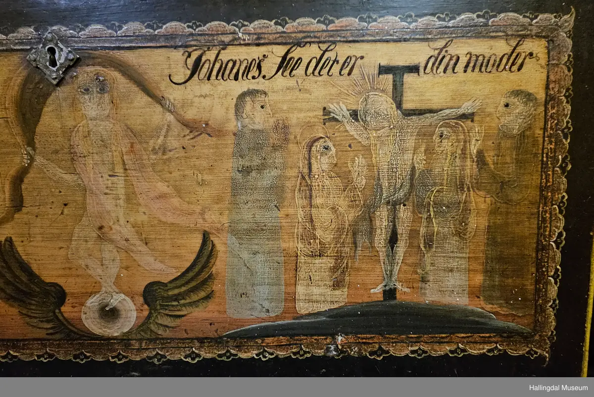 Skatoll med 3 like store skuffer pluss en mindre skuff over disse. På sidene av den øverste skuffen er det støtter som kan dras ut til platen som kan legges ned.  Platen er malt med 3 ulike motiv: Til venstre Maria og Josef med Jesusbarnet og 2 esler i stallen. I midten: En engel med rosa sjal som holder over hodet et brunt klede. Engelen står oppå en kule over englevinger. Til høyre: Jesus på korset med 2 damer og 2 menn.  
De 3 nederste skuffene er malt, 4 rosebuketter på hver skuff. Understellet er utskjært, ranke. 
Bak platen er det 6 små skuffer på hver side av et åpent rom.  Oppå skuffene og platen er det et buet skap med 2 hyller og øverst hylle for tallerker eller skjeer. Dørene har utskjærte speil som er rosemalt. Dørene er gråmalt på baksiden.
Bunnfargen på skatollet er mørk grønt og noe er brunrødt.
